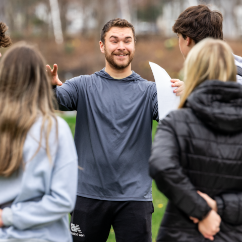 A UNE student gives game instructions to a group of high schoolers